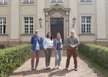 Czterech badaczy stoi przed wejściem do archiwum w Berlin-Dahlem.