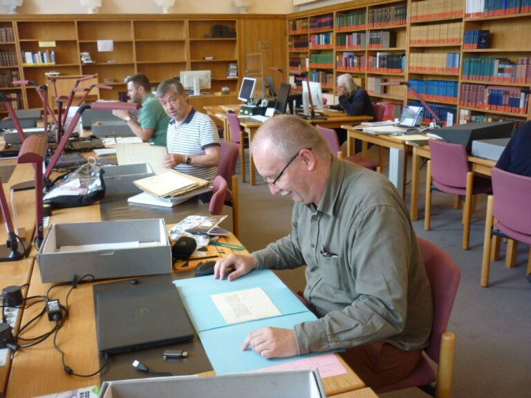 Profesor Szybkowski przegląda dokumenty w archiwum